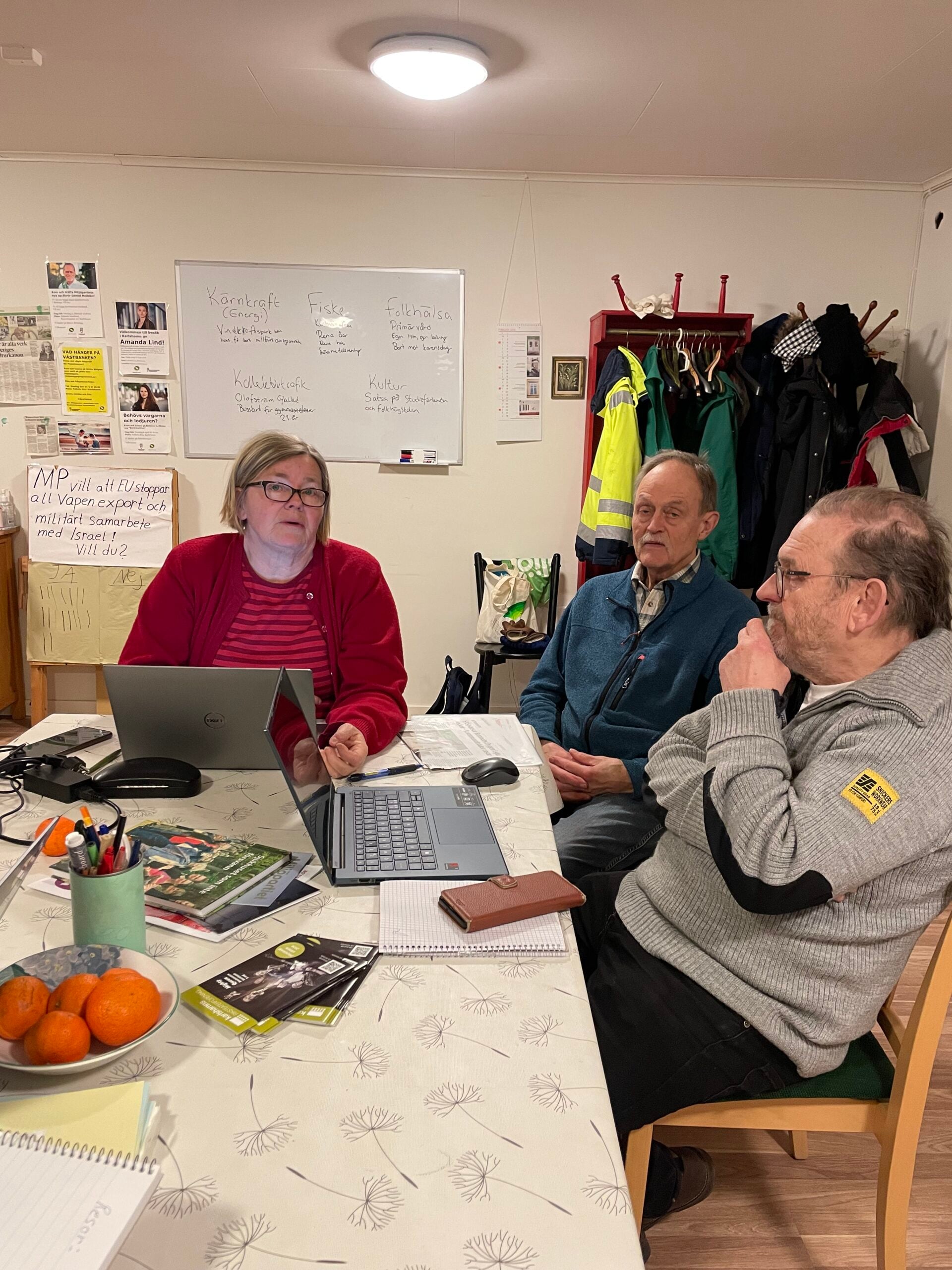 Tre personer sitter i partilokalen och planerar inför höstens val