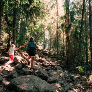 Mamma och barn vandrar i skogen