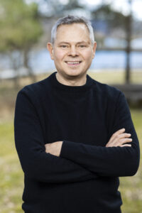 Vårt förstanamn Jonas Sjöblom står med armarna i kors i naturen.