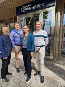 Toppkandidaterna Edvin, David, Emma och Peter står utanför ingången till Regionhuset och tittar in i kameran. 
