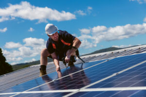 Bild på en man i arbetskläder som installerar solceller