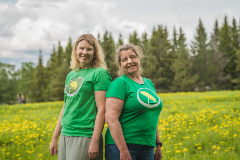Eva Ljungdahl och Linda Andersson, Miljöpartiets toppkandidater till kommunfullmäktige i Krokom inför valet 2026, står på en blommande äng.