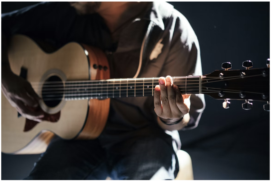En person som spelar gitarr