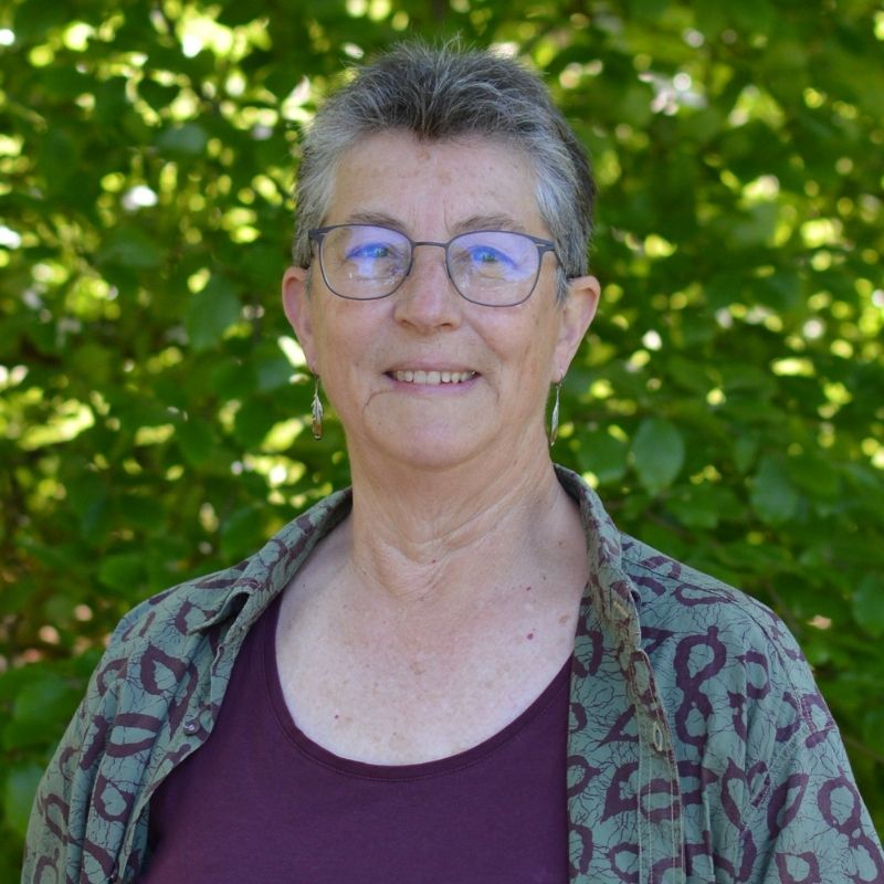 Porträtt av Cheryl Jones Fur utomhus framför grönska.