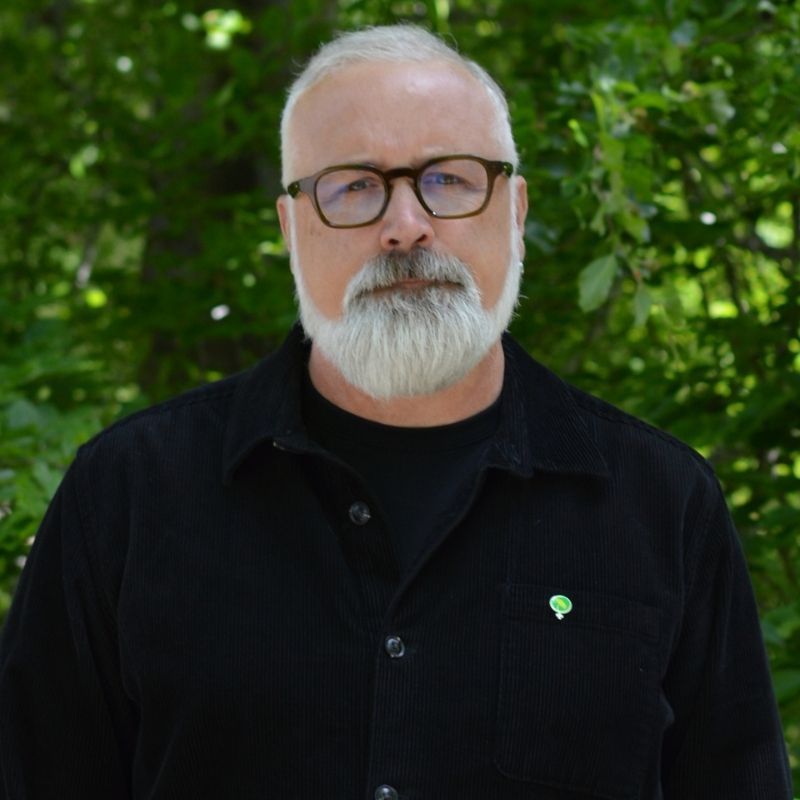 Porträtt av Magnus P Wåhlin i skogsmiljö.