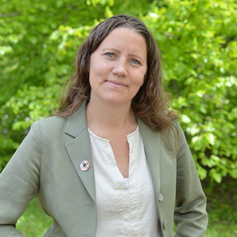 Porträtt av Pernilla Bodin utomhus framför grönska.