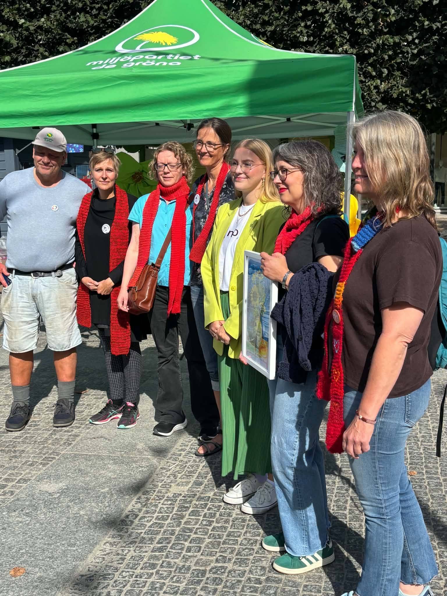 Linnea Kläth från Miljöpartiet de Gröna delar ut Sjuhärads miljöpris till representanter från Rebellmammorna vid valstugan på Stora torget i Borås.