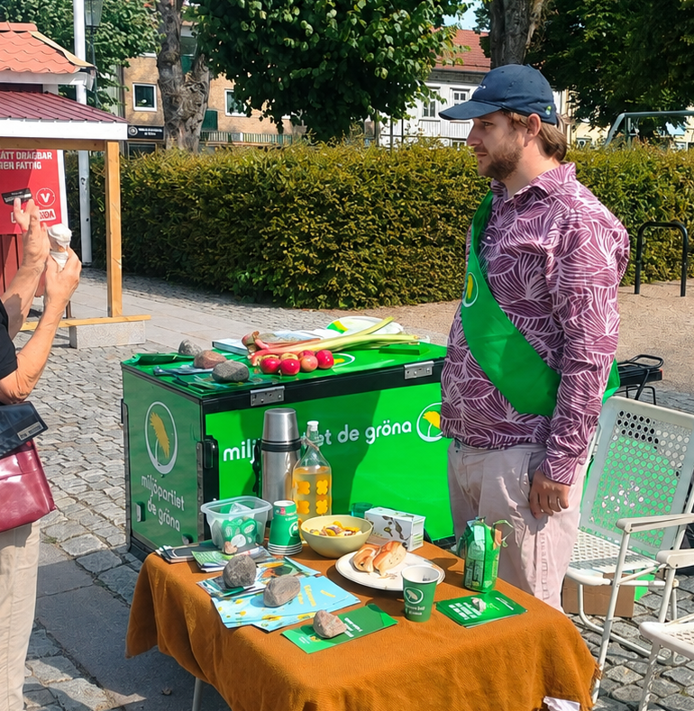 Miljöpartiet Vänersborg pratar politik vid kampanjbordet på torget.
